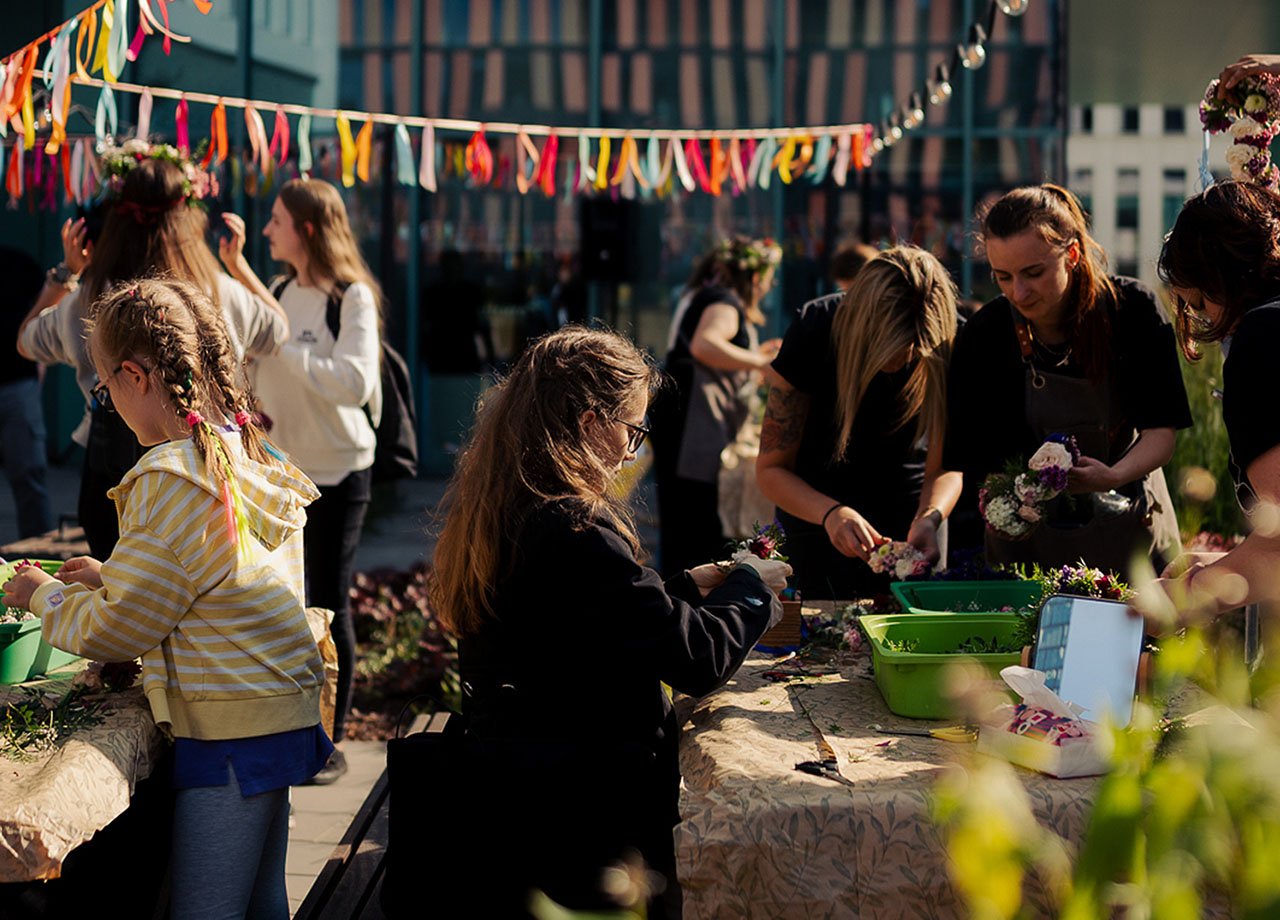 Event på innergård med mycket folk och vimplar. 