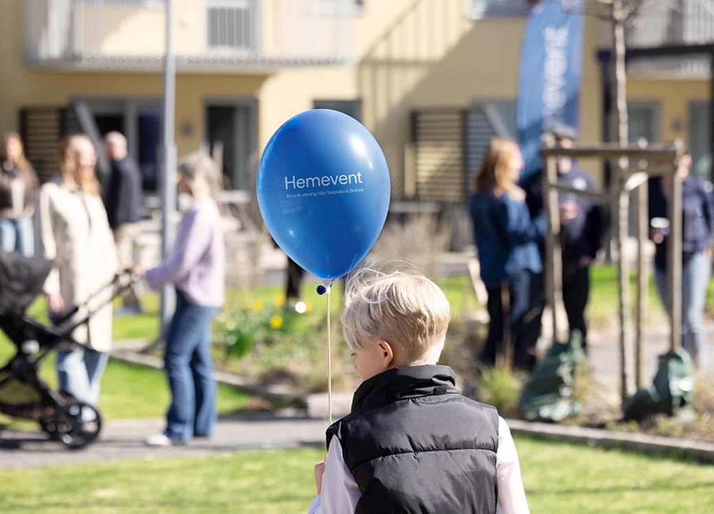 Event på innergård med pojk med ballong i handen och mycket folk.