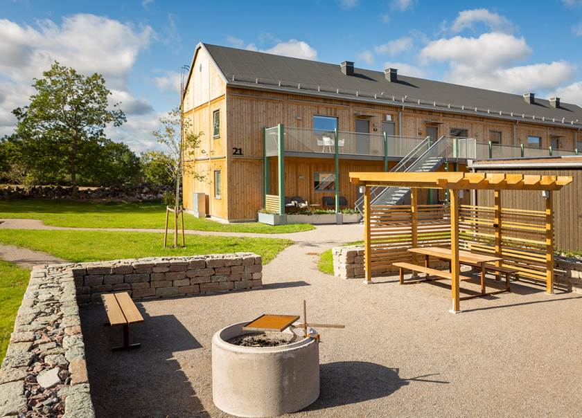 Grillplats med sittplatser och pergola i en innergård inramad av ölandssten i BoKlok Gläntan på Öland Grillplats med sittplatser och pergola i en innergård inramad av ölandssten i BoKlok Gläntan på Öland
