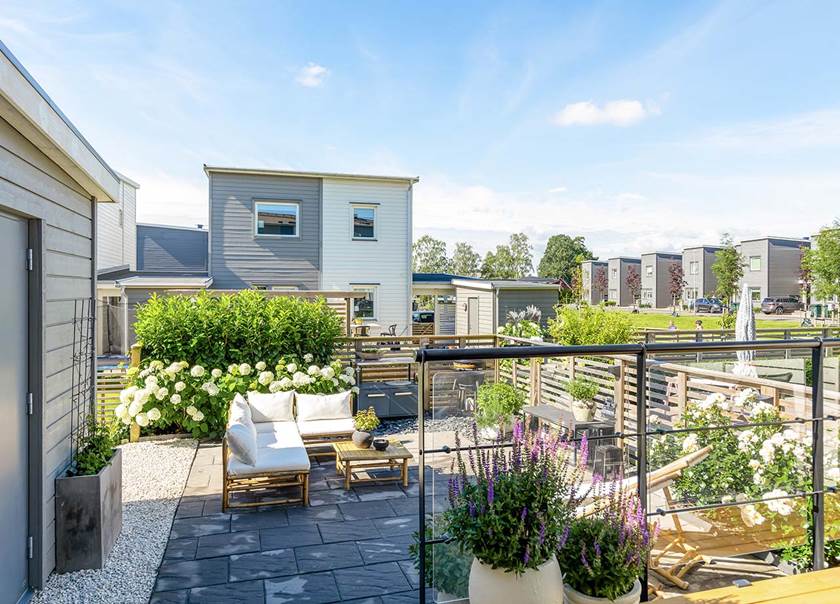 Uteplats till grått BoKlok enfamiljshus.