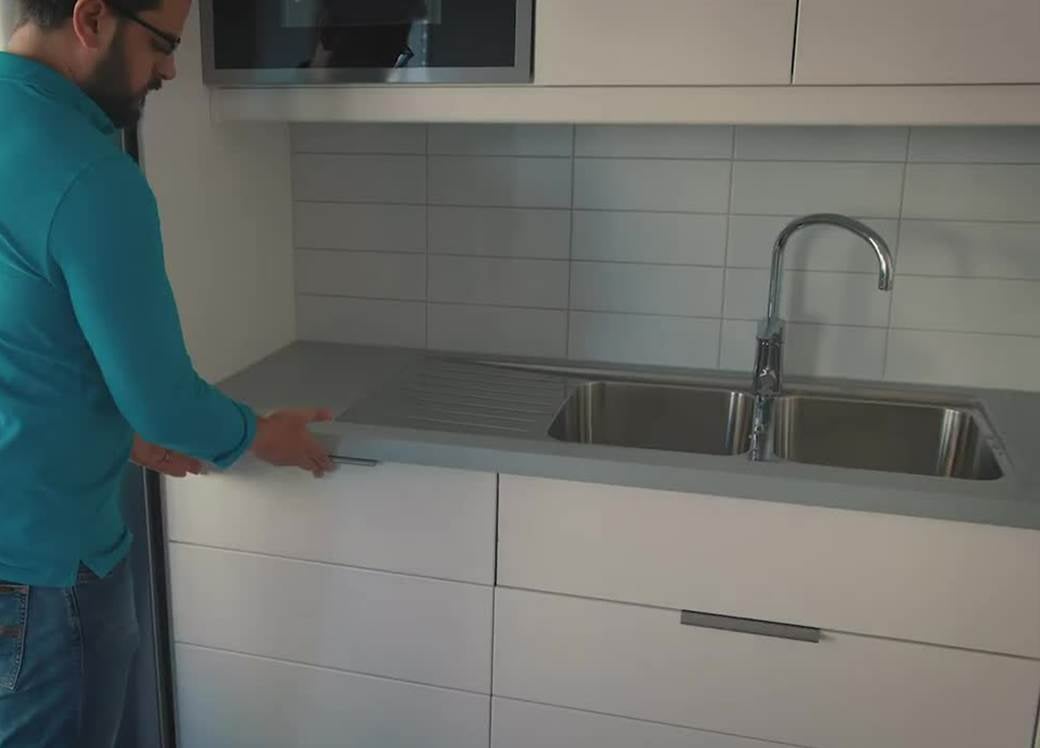 Man i kök på väg att öppna diskmaskin.