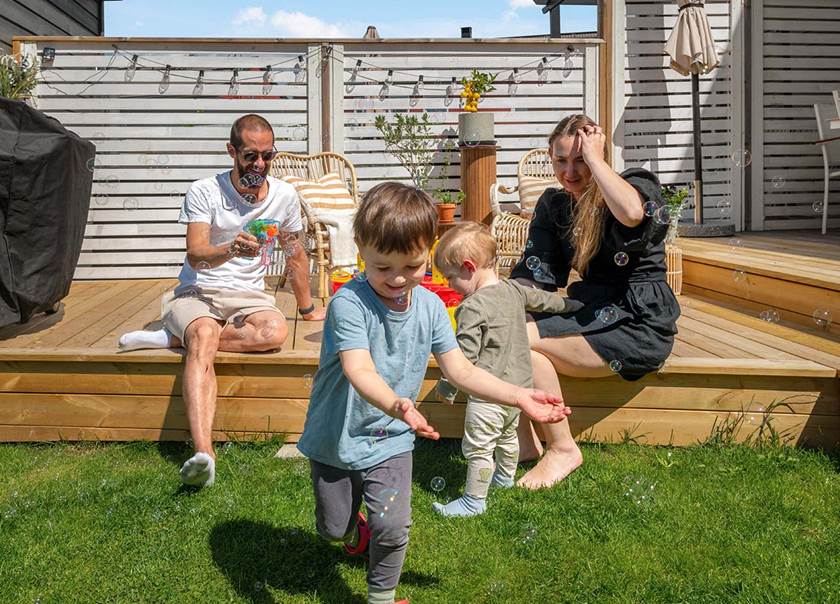 Familj leker med sopbubblor på altan till BoKlok radhus i Tungelsta. Familj leker med sopbubblor på altan till BoKlok radhus i Tungelsta.