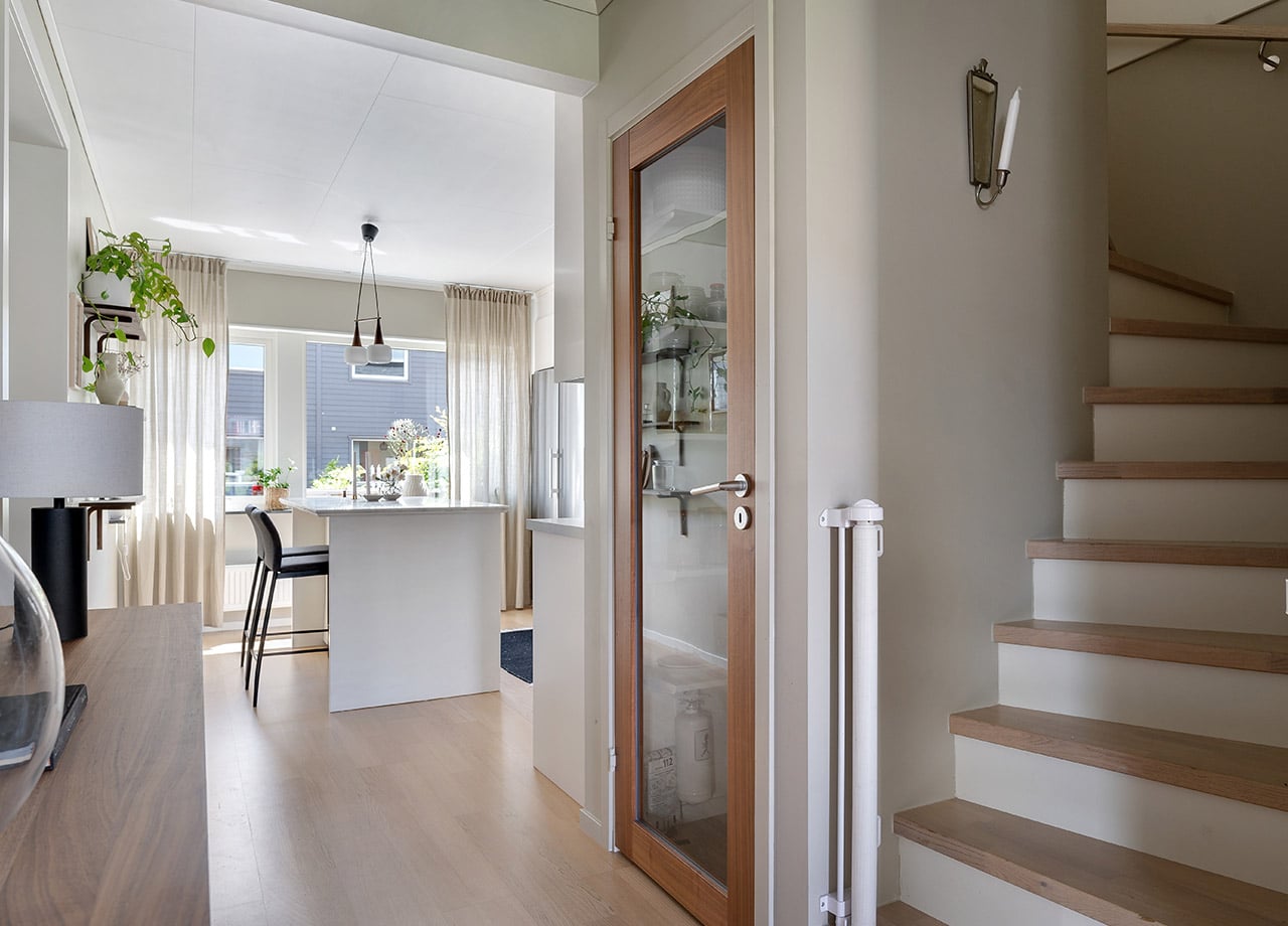 Glasdörr till skafferi mellan kök och trapp i ett hus.