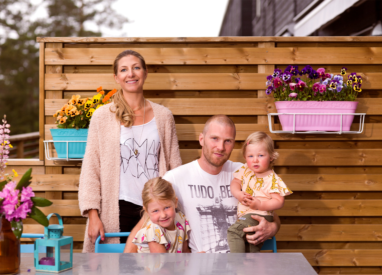 Familj på två vuxna och två barn på altan