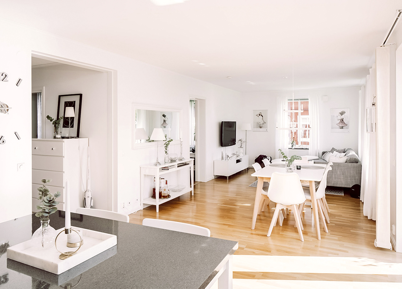 Köksö och öppet till vardagsrum med soffa och matbord