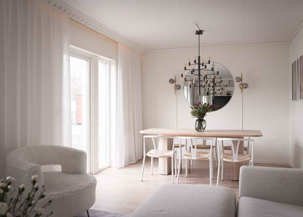 Matbord med blomma i vas och taklampa över bord i vardagsrum