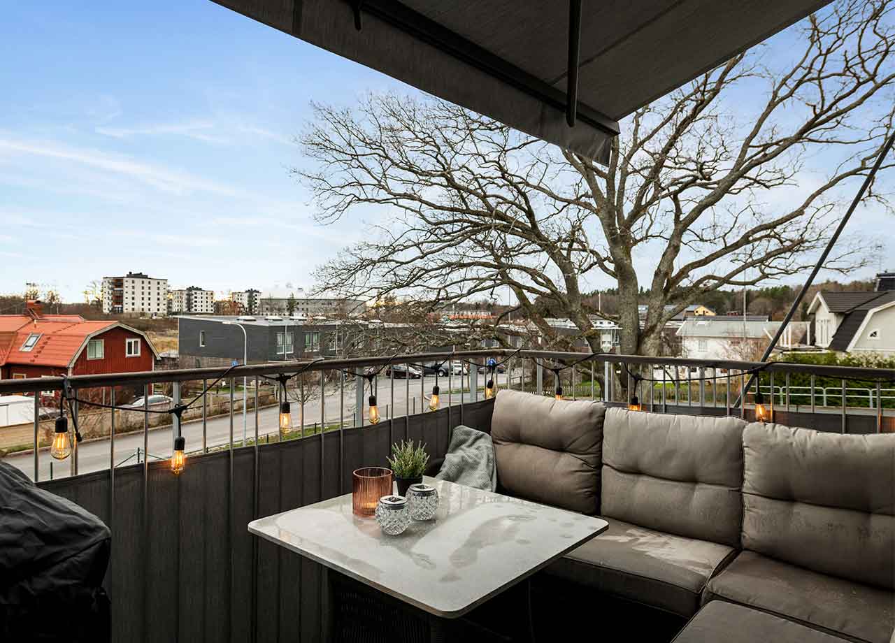 Balkong med belysning, bord och soffa