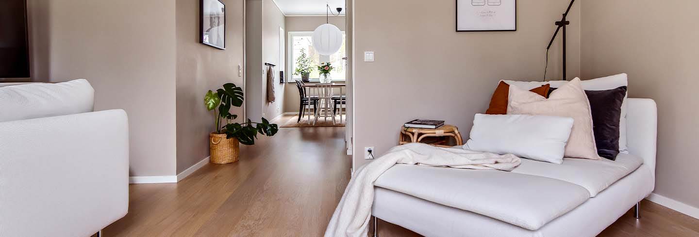 Vit fåttölj i hörnet i vardagsrummet hemma hos familjen Lindblom Vit fåttölj i hörnet i vardagsrummet hemma hos familjen Lindblom