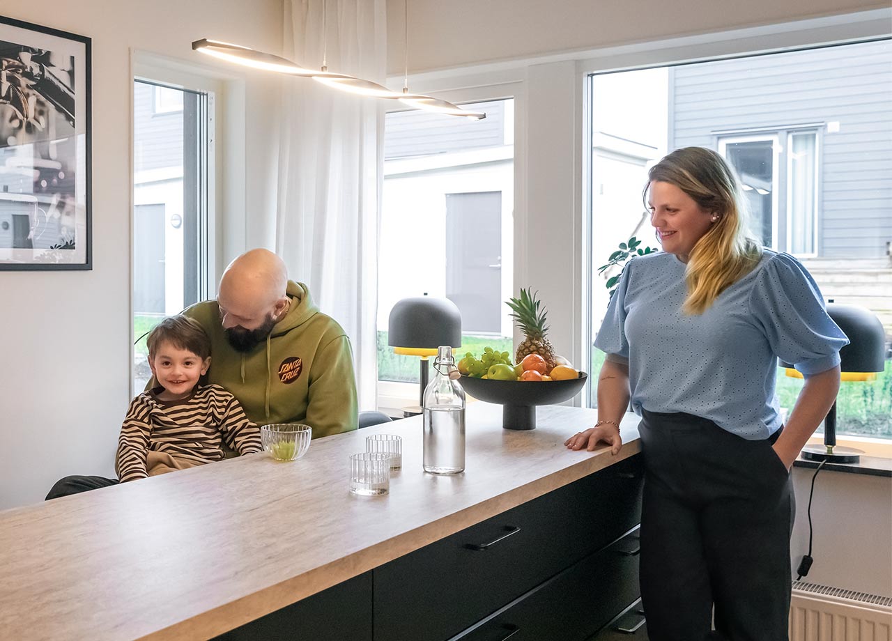 Familj på tre vid köksö