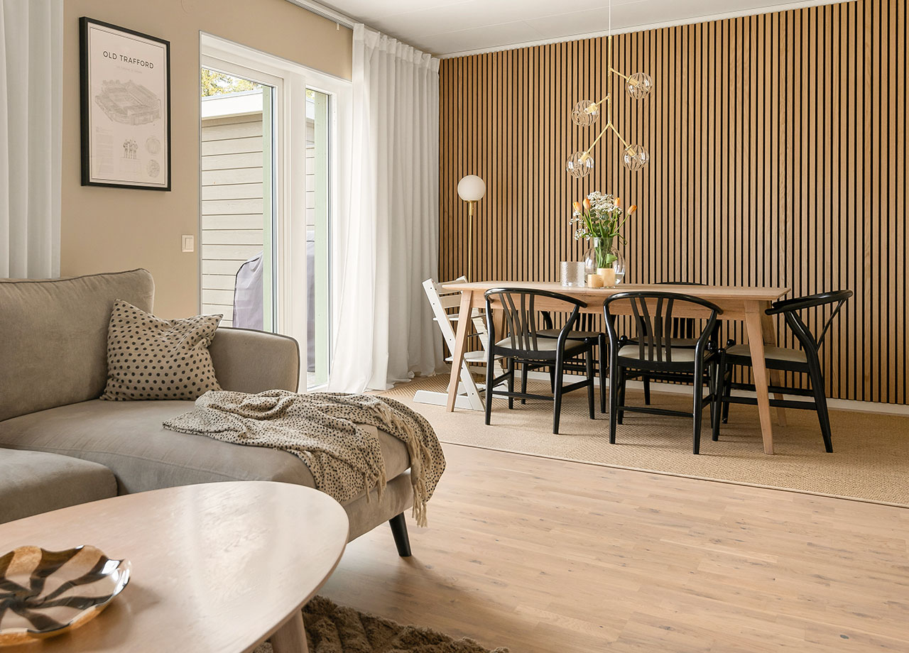 Beige soffa, matbord och akustisk panel på väggen