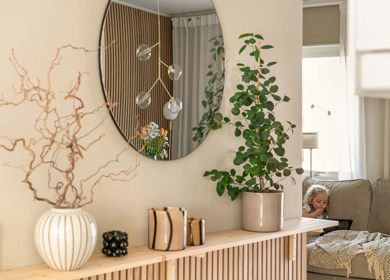 Hylla med accessoarer och flicka som skymtas på soffa