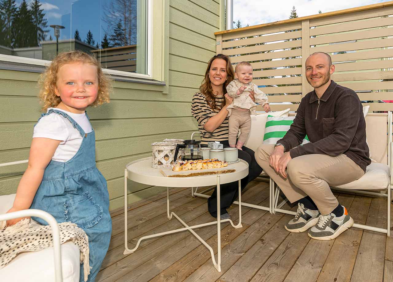 Kvinna och man med två små barn på altan