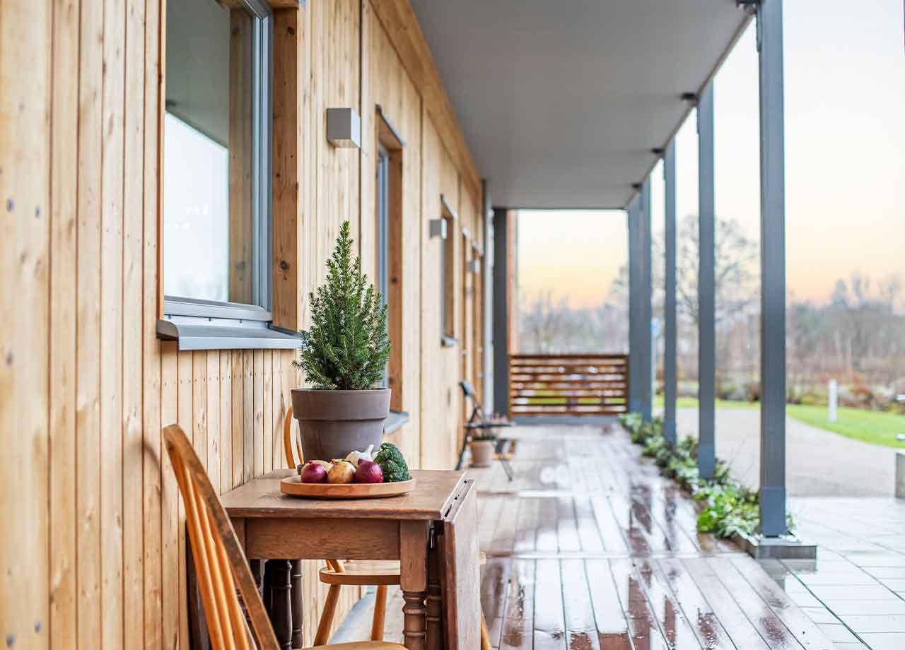 Loftgång till lägenhetshus med bord och stol på