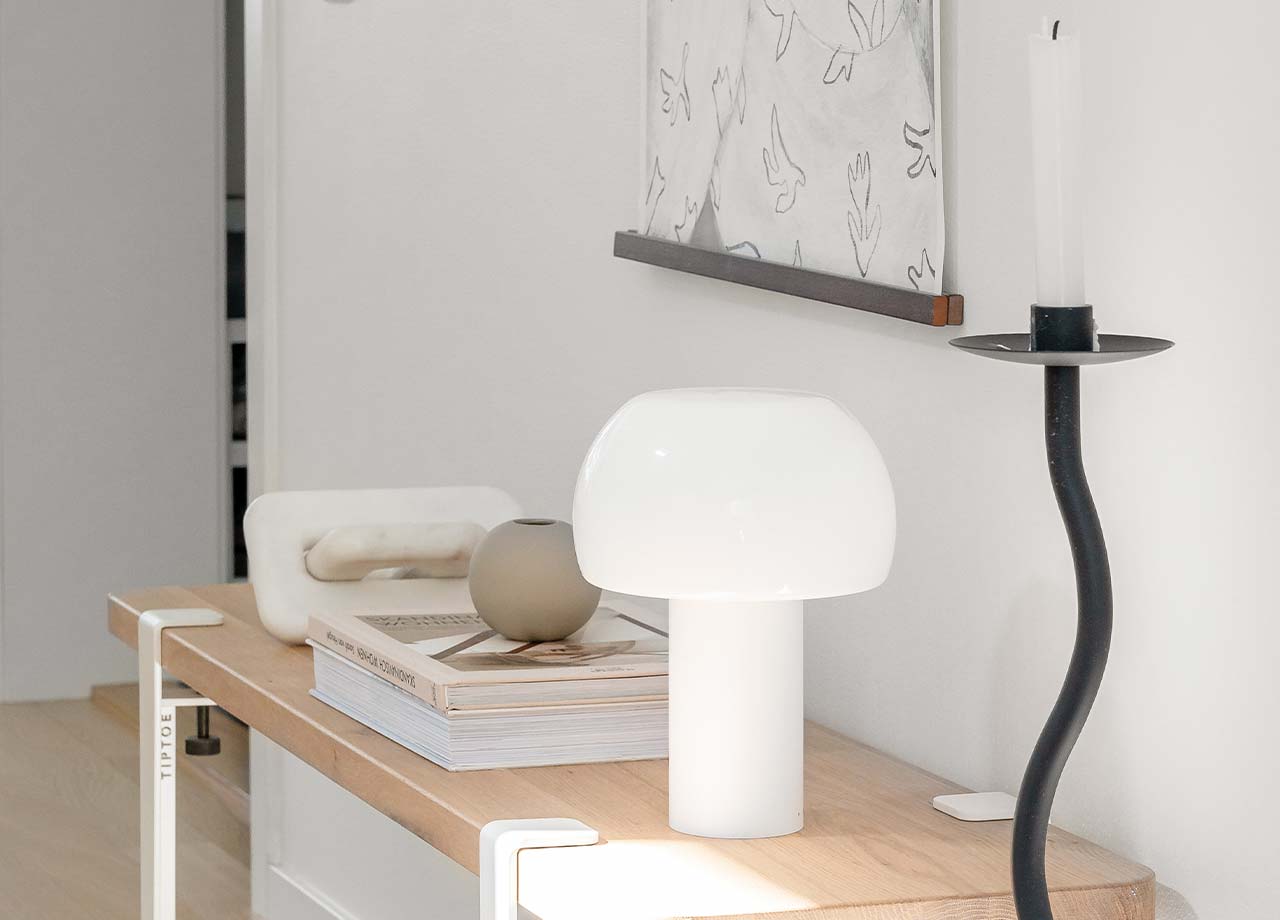Byrå med ljusstake och lampa på.
