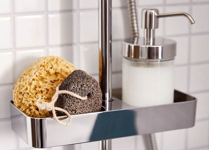 Duschtillbehör som tvättsvamp och tvålpump på duschhyllan