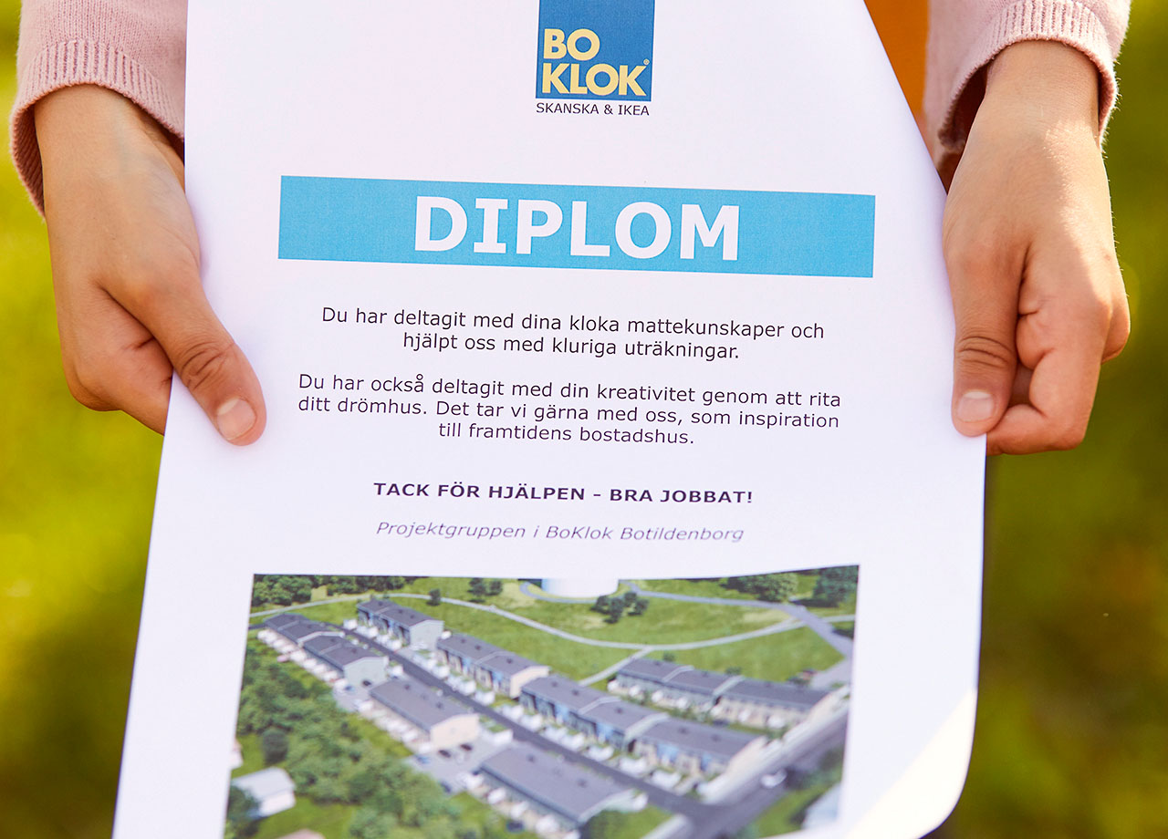 Händer som håller upp ett diplom.