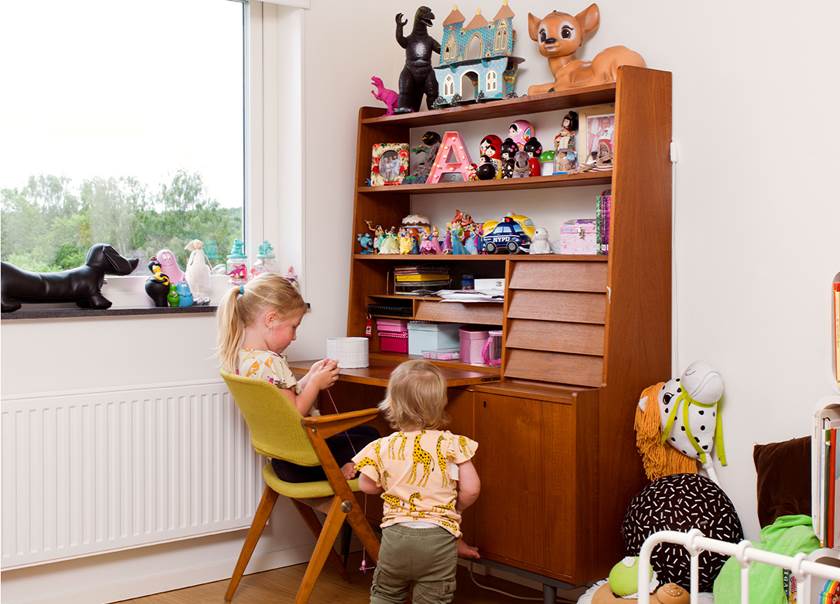 Två barn leker i barnrummet vid retro teak möbel i familjen Beijers BoKlok radhus