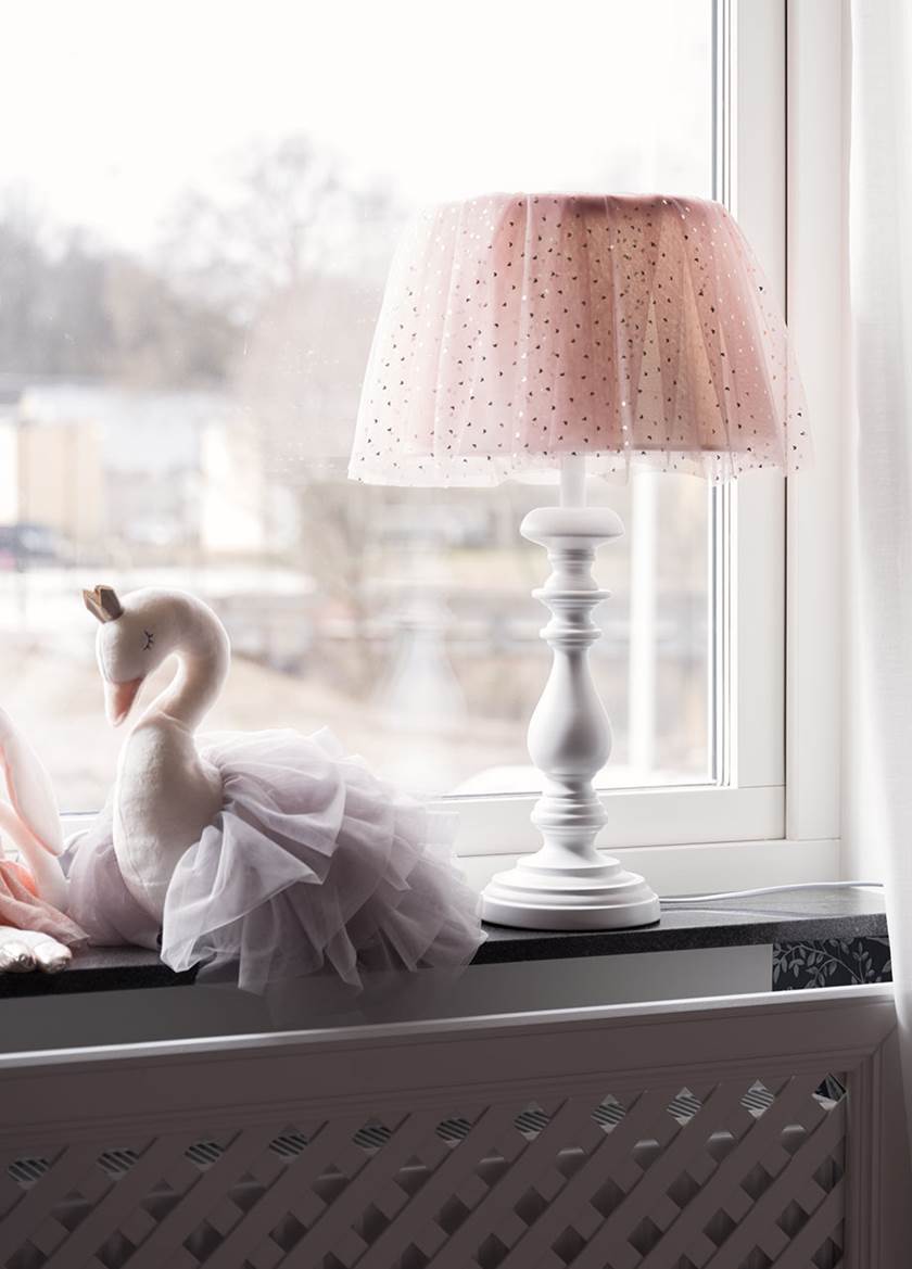 Liten tygsvan och en vit lampa med rosa skräm i tyll.