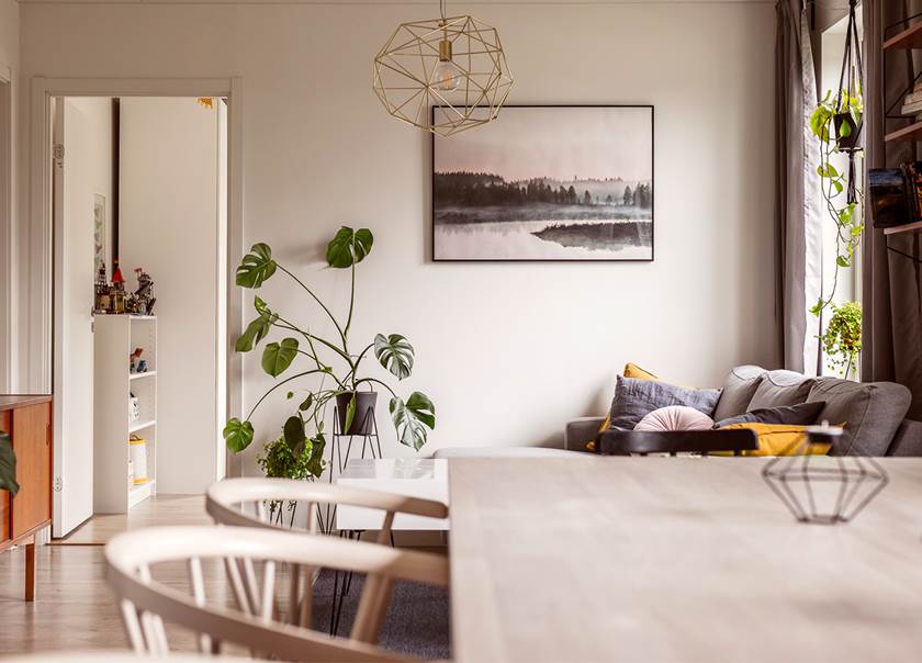 Öppet mellan kök med matplats och vardagsrum med soffa hemma hos familjen Engströms BoKlok lägenhet