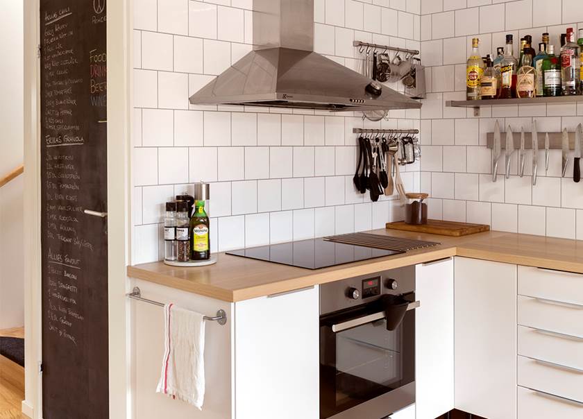 Köket med vitt kakel rostfri fläkt öppna hyllor hemma hos Hellström-Kjellström som bor i ett Boklok radhus