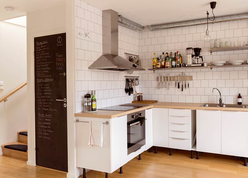 Vitt kök med rostfri fläkt vitt kakel och öppna hyllor hemma hos familjen Hellström-Kjellström