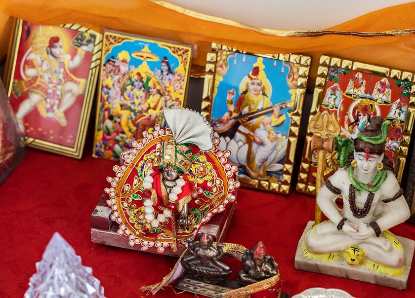 indiskt altare med bilder och figurer på röd sammet