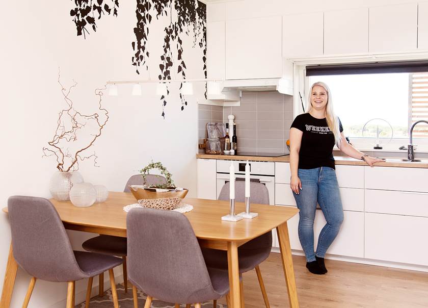 Emma Malmborg står vid köksbänken i köket i sin BoKlok lägenhet