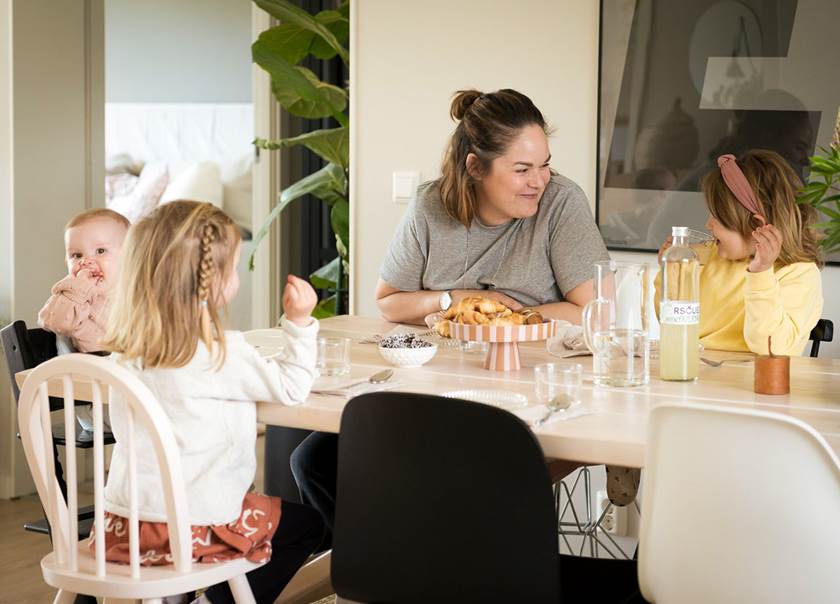 mamma och döttrar fikar runt matbordet i sitt kök