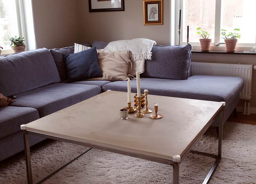 Blå hörnsoffa och soffbord med ljus på i vardagsrummet hemma hos familjen Storm 