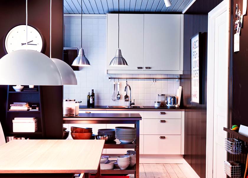 Vitt kök med vitt kakel och svarta väggar med köksbord i ek.