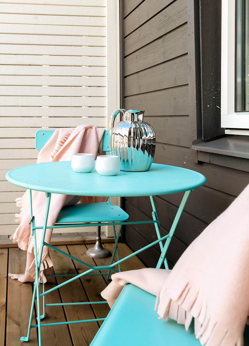 turkosa möbler på balkongen med dukning och rosa kuddar