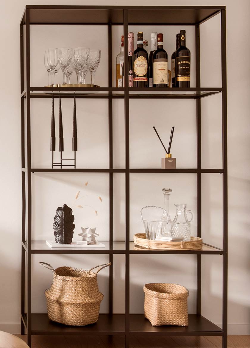 Korgar, ljus och vaser i förvaringshyllan Vittsjö från IKEA med svart metallram och hyllplan i klarglas.