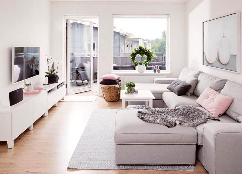 Vardagsrummet med soffa TV och öppen balkongdörr i BoKlok lägenhet hemma hos familjen Zaidan