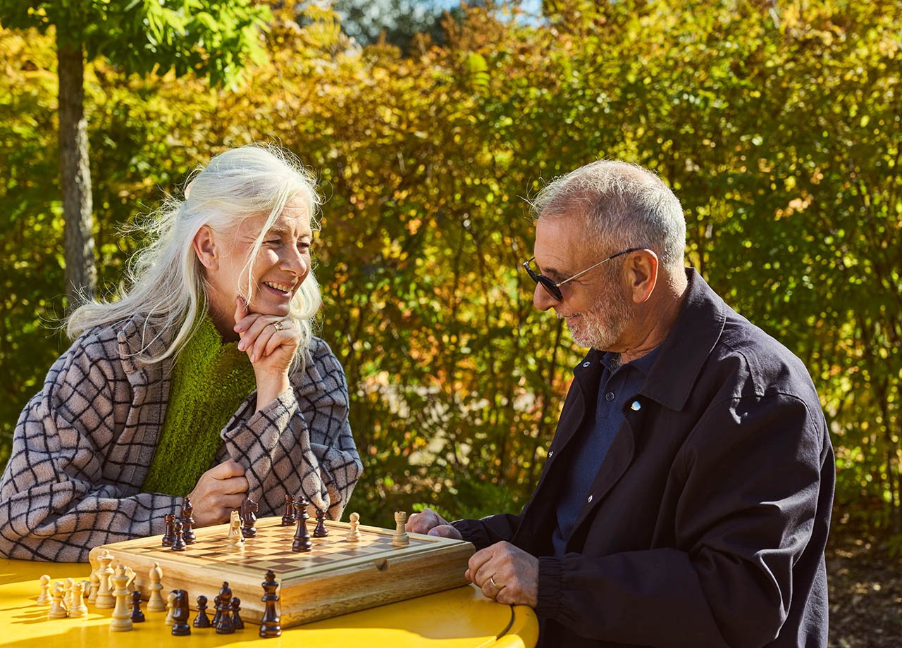 Par spelar schack utomhus.
