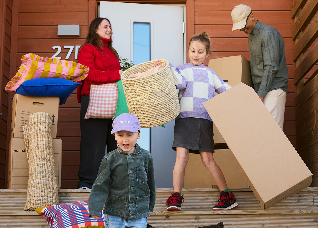 Familj med flyttkartonger vid entré.