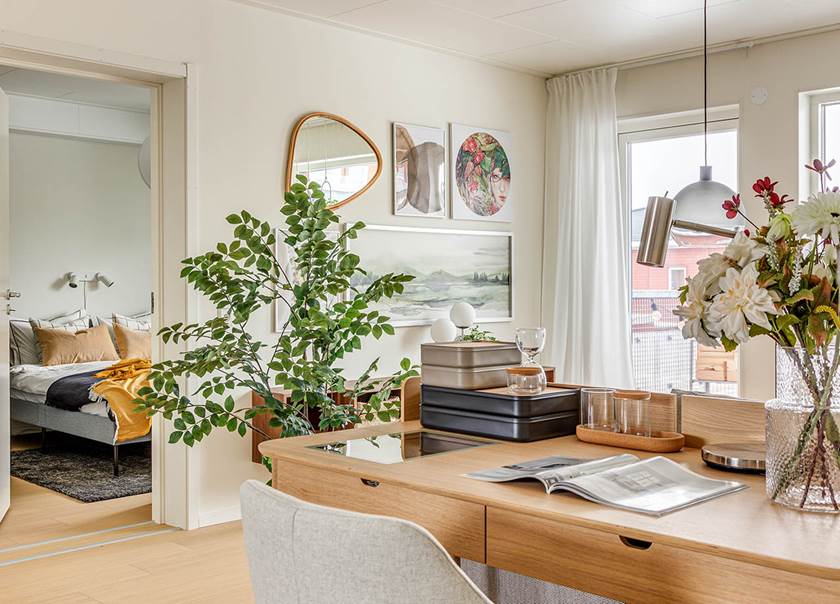 Vy över matbord i allrum med öppen dörr intill sovrum