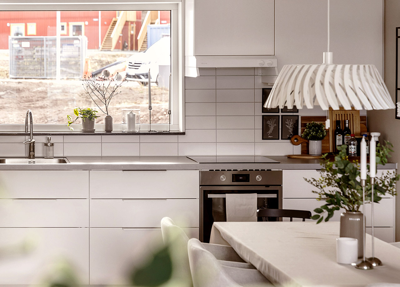 Kök med vita köksluckor och fönster över diskbänk i BoKlok lägenhet 3 rum och kök.