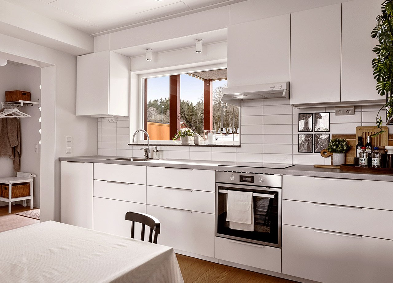 Kök med vita köksluckor och fönster över diskbänk i BoKlok lägenhet 3 rum och kök.