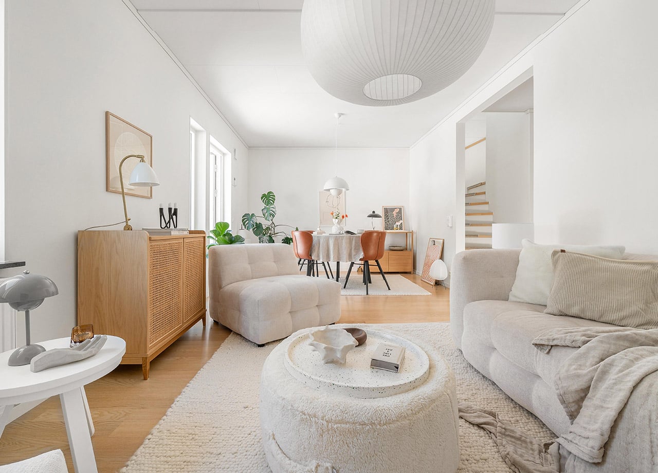 Ljust vardagsrum med soffgrupp och matplats i BoKlok radhus.