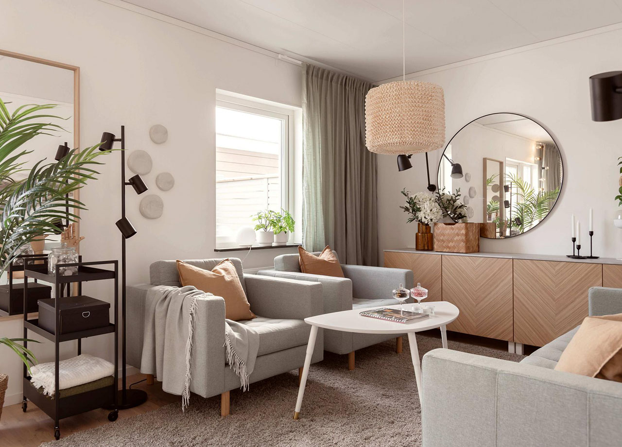 Vardagsrum med soffa, soffbord, fåtöljer och skåp i BoKlok radhus 117 kvm
