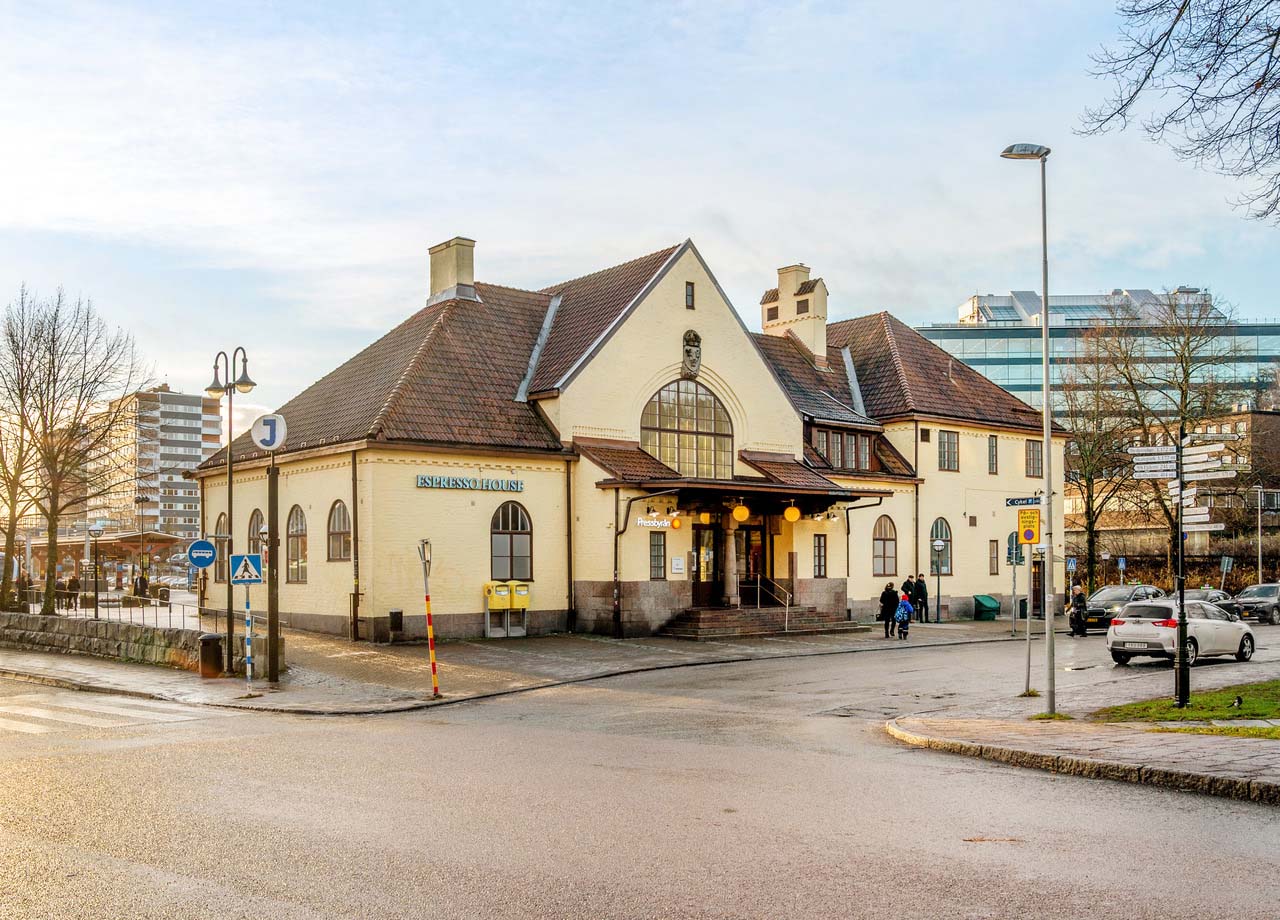 Foto på Södertälja stationsbyggnad i gul puts och rött tegeltak