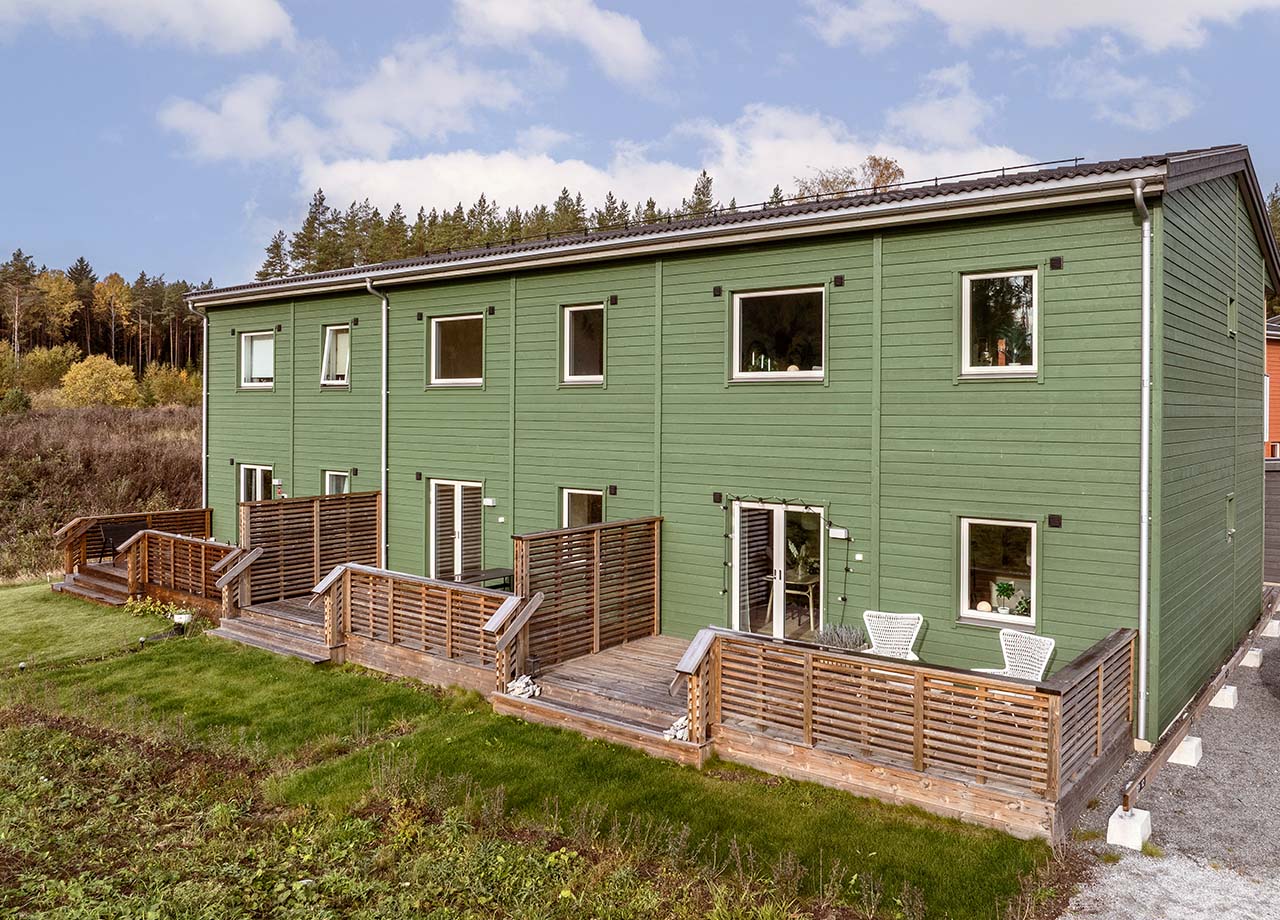 Foto av baksida till ett grönt radhus i BoKlok Kronan.