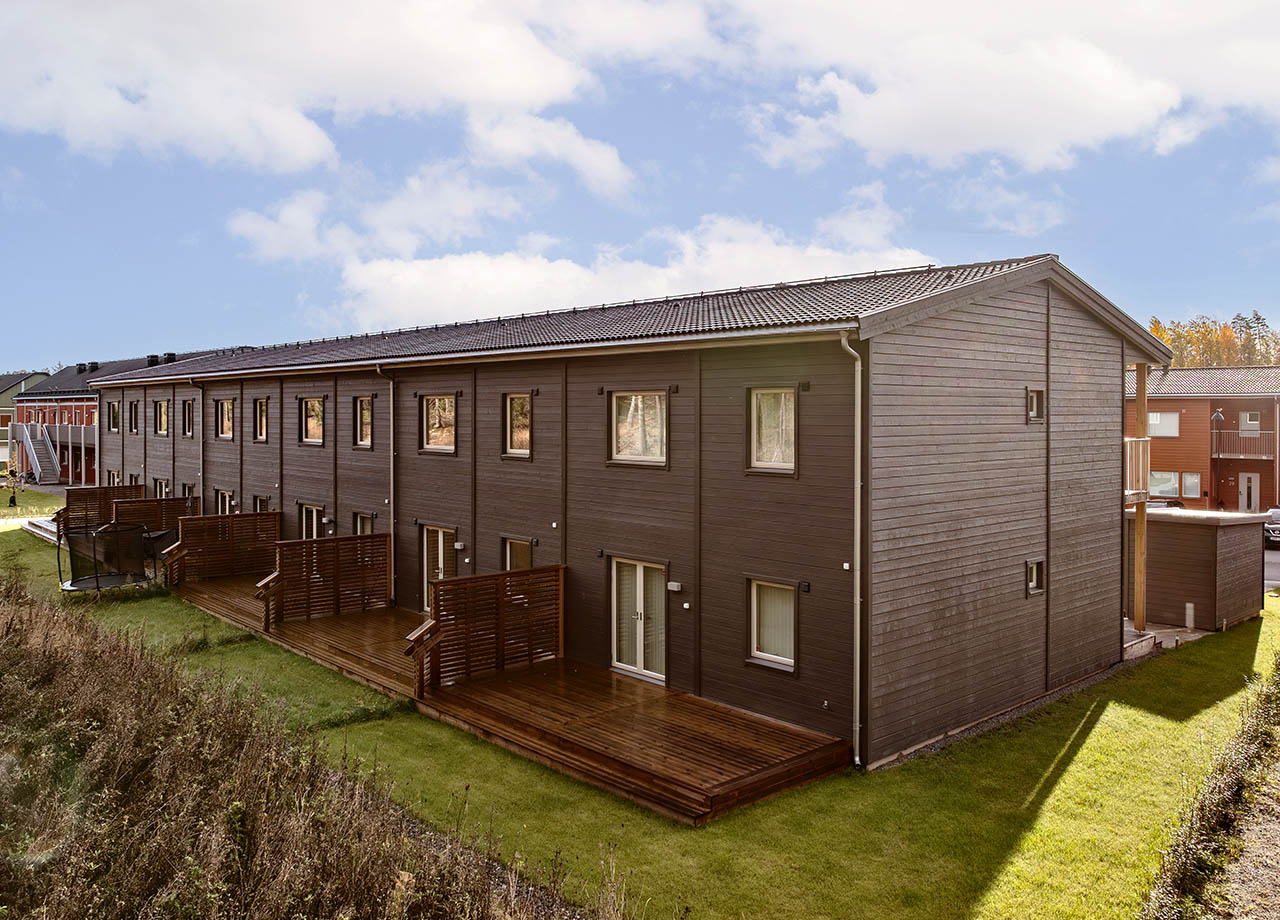 Baksida med altan och täppa till grå radhuslänga i BoKlok Kronan.