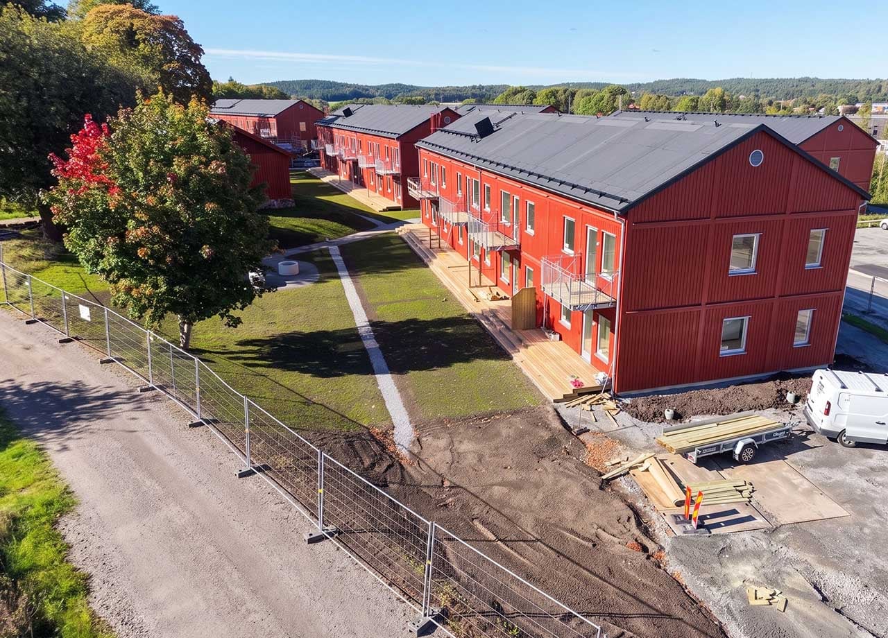 BoKlok_Lavendeln_röda_lägenhetshus_med_balkonger_och_altaner_byggstängsel