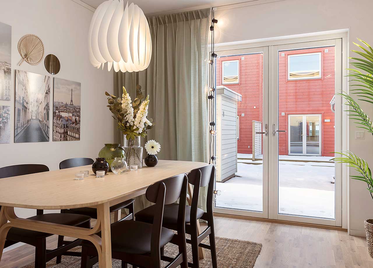 Vardagsrummet med plats för soffa, soffbord, fåtöljer och matbord i BoKlok radhus 117 kvm