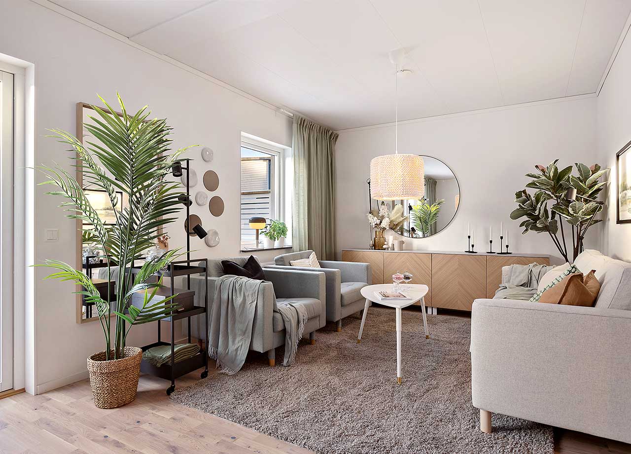 Vardagsrummet med plats för soffa, soffbord, fåtöljer och skåp i BoKlok radhus 117 kvm