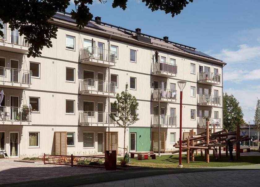 Vitt lägenhetshus i fyra våningar i BoKlok Rubinen  i Bäckby Centrum i Västerås