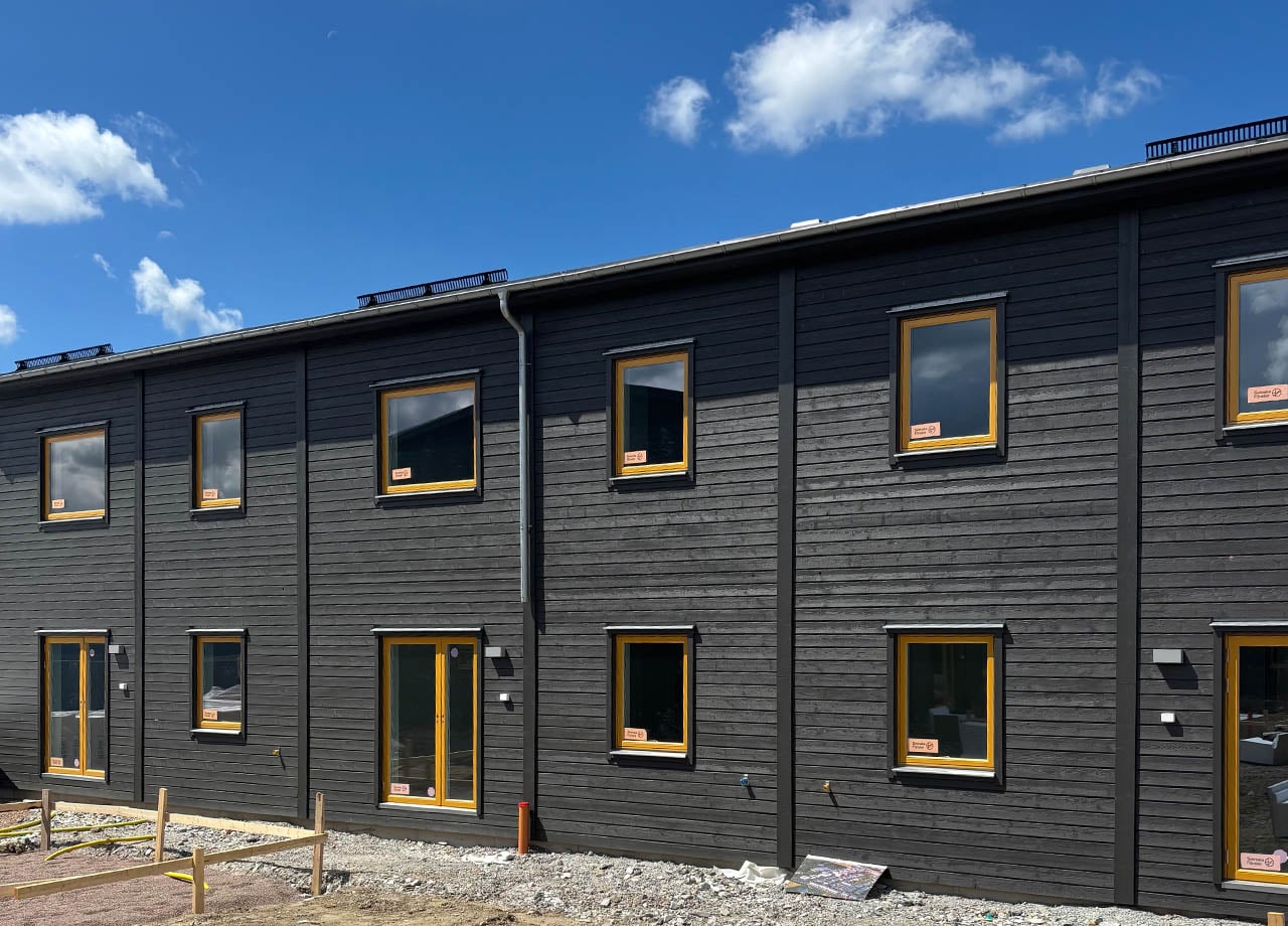 Grått radhus med gula detaljer i BoKlok Sandallén.