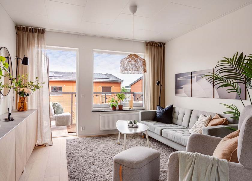 Vardagsrum öppet till balkongen med utsikt över hustaken i BoKlok Vattentornet i Malmö